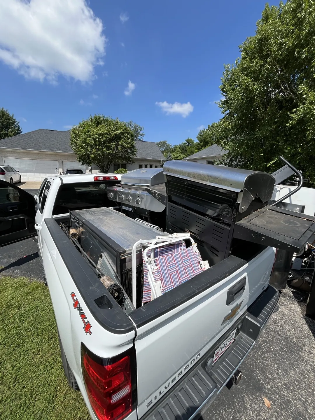 Indy Pickup 1111 pickup truck loaded with scrap metal and an old appliance after a residential collection
